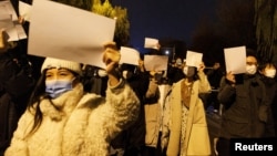 北京民眾手舉白紙上街遊行，抗議中國嚴厲的防疫政策，悼念烏魯木齊火災死難者。（2022年11月27日）