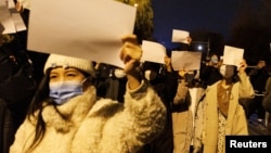 资料照：北京女子手举白纸游行，抗议中国严厉的防疫政策，悼念乌鲁木齐火灾死难者。（2022年11月27日）