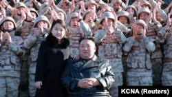 Lide Kore di No Kim Jong Un ak pitit fi li fe foto ak savan, enjenye ak responsab milite ki te travay sou ese nouvo misil Hwasong-17 enekontinantal la (ICBM) nan foto sa a ke ajans nouvel Kore di No a pataje ak lapres.