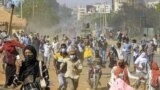 FILE: Protesters flee before a Sudanese security forces armed vehicle in clashes during a demonstration against a tentative deal aimed at ending the crisis provoked by last year's military coup, in the Bashdar district in the south of Sudan's capital Khartoum on December 19, 2022