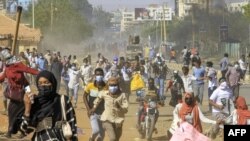 FILE: Protesters flee before a Sudanese security forces armed vehicle in clashes during a demonstration against a tentative deal aimed at ending the crisis provoked by last year's military coup, in the Bashdar district in the south of Sudan's capital Khartoum on December 19, 2022