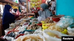 Seorang pedagang tengah melayani seorang pembeli di pasar tradisional di Jakarta, 2 Januari 2023. (REUTERS/Ajeng Dinar Ulfiana)