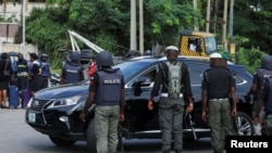 FILE - Police officers stop a vehicle at a checkpoint in Abuja, Nigeria, Oct. 21, 2021.
