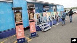 FILE - People stand by the All of Us Mobile Education and Enrollment Center at the Community Health Center on State Street in Meriden, Conn., May 13, 2019. (Dave Zajac/Record-Journal via AP, file)