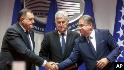 Bosnian Serb leader Milorad Dodik, left and Bosniac leader Nermin Niksic shake hands in Sarajevo, Bosnia, Dec. 15, 2022. Three diplomats told The Associated Press that Bosnia has been granted candidate status into the European Union.