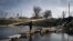 A man crosses the river on the debris of a damaged bridge in Bakhmut, the site of the heaviest battles with the Russian troops, in the Donetsk region, Dec. 11, 2022. 