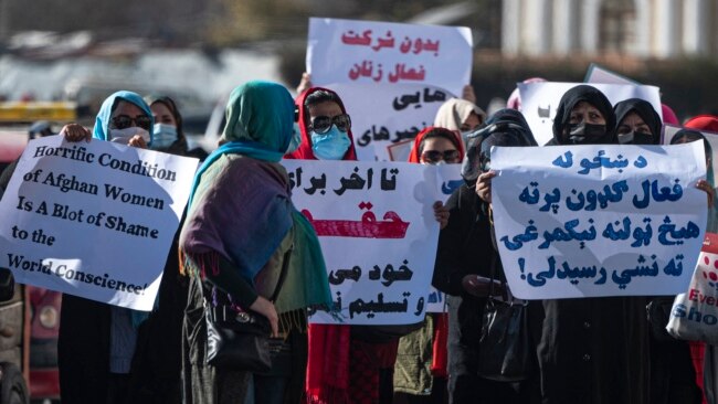 Women hold placards during a protest calling for their rights to be recognized, near the Shah-e-Do Shamshira mosque in Kabul, Nov. 24, 2022. Afghan women have been squeezed out of public life since the Taliban's return to power in August 2022.