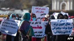 Sejumlah perempuan memegang plakat selama aksi protes menuntut pengakuan hak-hak kaum perempuan, di dekat masjid Shah-e-Do Shamshira di Kabul, hari Jumat 24 November 2022. 