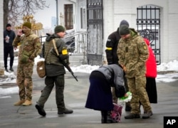 Members of Ukraine's secret service examine belongings of a parishioner at the entrance to the Pechersk Lavra monastic complex in Kyiv, Ukraine, Nov. 22, 2022.