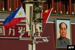 Bendera nasional Filipina dan China terlihat bersama di dekat Gerbang Tiananmen saat Presiden Filipina Ferdinand Marcos Jr berkunjung, di Beijing, 3 Januari 2023. (Noel CELIS / AFP)