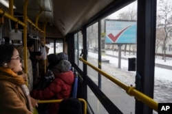 FILE - An election poster, in the background, is seen through a bus window in Almaty, Kazakhstan, Nov. 17, 2022.