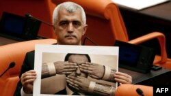 Peoples' Democratic Party MP Omer Faruk Gergerlioglu holds a photograph depicting censorship while attending a session on a government-sponsored bill that criminalizes "disinformation" at the Turkish Grand National Assembly on Oct.13, 2022, in Ankara.