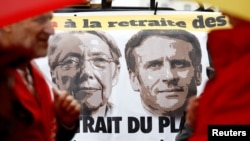 A banner depicting French Prime Minister Elisabeth Borne and French President Emmanuel Macron is pictured as protesters demonstrate against pension reform in Rennes, France, Jan. 10, 2023. 