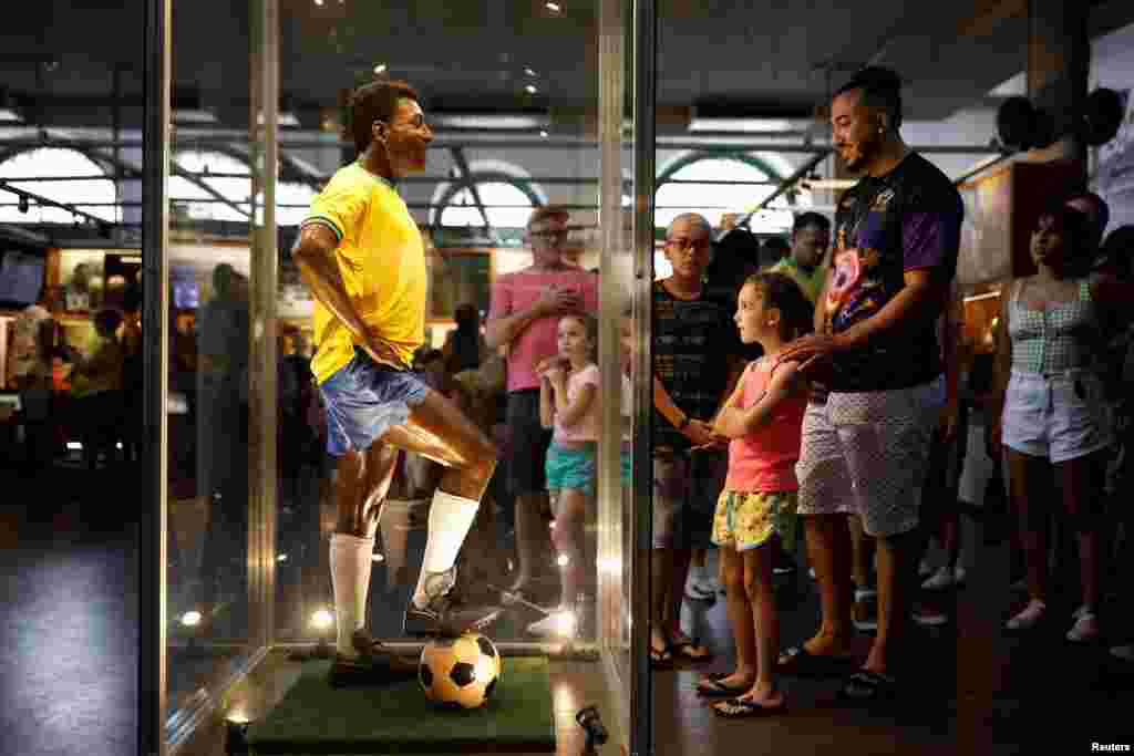 A wax sculpture of Brazilian soccer legend Pele stands in Pele Museum as people mourn his death, in Santos, Brazil.
