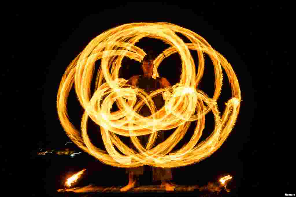 A performer takes part in a fire show at the beach in Phuket, Thailand.