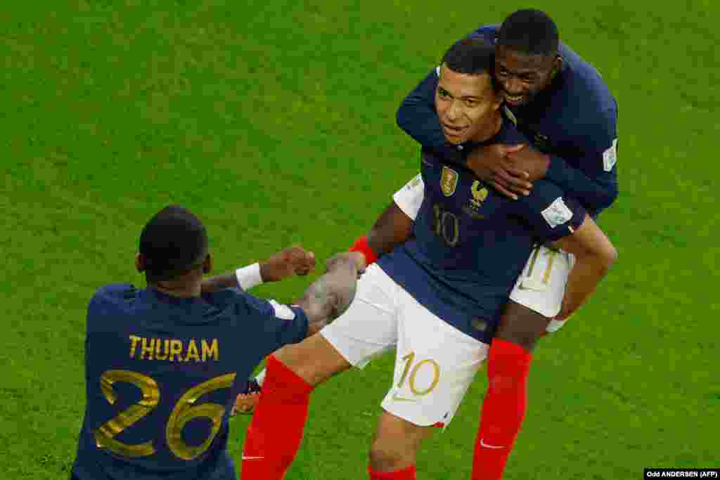 Jogadores franceses Kylian Mbappe (10) Marcus Thuram (26) e Ousmane Dembele (11) celebram golo da França contra a Polónia. A França eliminou a Polónia e avançou para o quartos-de-final do Mundial do Qatar. 4 dezembro, 2022