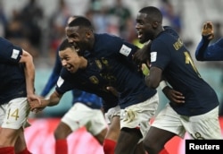 France's Kylian Mbappe, Marcus Thuram and Dayot Upamecano celebrate after the match as France progress to the World Cup 2022 quarter finals on December 4, 2022.