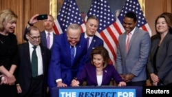 Ketua DPR AS Nancy Pelosi (D-CA) menandatangani "The Respect for Marriage Act" bersama sesama anggota Kongres, selama upacara pendaftaran tagihan di Capitol Hill, di Washington, AS, 8 Desember 2022. REUTERS/Evelyn Hockstein