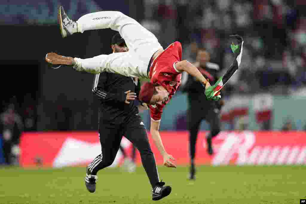 A pitch invader jumps during a World Cup group D soccer match between Tunisia and France at the Education City Stadium in Al Rayyan, Qatar.
