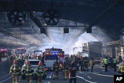 Petugas pemadam kebakaran bekerja memadamkan api di jalan raya di Gwacheon, Korea Selatan, Kamis, 29 Desember 2022. (Foto: via AP)