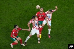 Morocco's Selim Amallah jumps for the ball between Croatia's Bruno Petkovic and Nikola Vlasic, right, during the World Cup third-place playoff soccer match between Croatia and Morocco at Khalifa International Stadium in Doha, Qatar, Dec. 17, 2022.