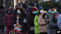 Sejumlah warga mengantre untuk menjalani tes usap COVID-19 di tengah udara dingin yang melanda Beijing pada 4 Desember 2022. (Foto: AP/Andy Wong)