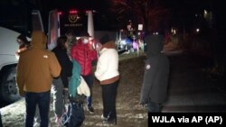 FILE: This photo from WJLA-TV shows migrant families boarding a bus to transport them from the area around the residence of US Vice President Kamala Harris to an area church after arriving in Washington, D.C. Taken December 24, 2022