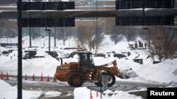 Seorang pekerja menggunakan alat berat untuk menghilangkan salju di Bandara Internasional Buffalo Niagara, setelah badai salju Natal yang mematikan, di Cheektowaga, New York, 27 Desember 2022. (Foto: Reuters)