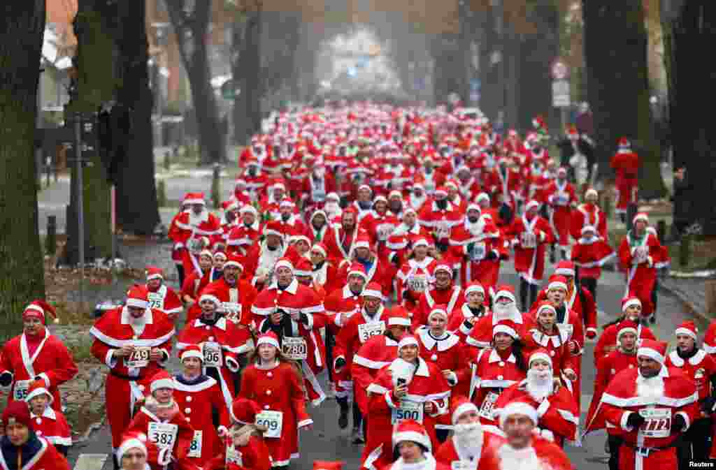 People dressed as Santa Claus take part in the Nikolaus Lauf (Saint Nicholas run), in the streets of Michendorf, Germany.