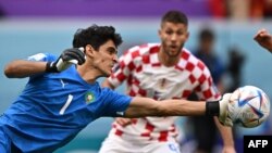 Le gardien de but marocain # 01 Yassine Bounou et l'attaquant croate # 09 Andrej Kramaric regarde pendant le match de football du groupe F de la Coupe du monde Qatar 2022 entre le Maroc et la Croatie.