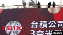 Pekerja konstruksi berdiri saat perusahaan raksasa cip TSMC mengadakan upacara untuk memulai produksi massal cip 3 nanometer tercanggihnya di Tainan, Taiwan, 29 Desember 2022. (Foto: REUTERS/Ann Wang)