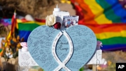 Handwritten messages cover the heart attached to the cross to honor a victim of the mass shooting at a gay nightclub at a makeshift memorial near the scene of the crime Nov. 23, 2022, in Colorado Springs, Colo.