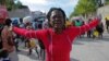 Rose Delpe llora mientras las personas desplazadas por la violencia de la guerra de pandillas en Cite Soleil caminan por las calles del barrio de Delmas después de salir de la plaza Hugo Chávez en Puerto Príncipe, Haití, el 19 de noviembre de 2022. 