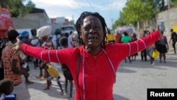 Rose Delpe llora mientras las personas desplazadas por la violencia de la guerra de pandillas en Cite Soleil caminan por las calles del barrio de Delmas después de salir de la plaza Hugo Chávez en Puerto Príncipe, Haití, el 19 de noviembre de 2022. 