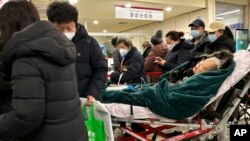 An elderly patient is pushed along a corridor of the emergency ward at a hospital in Beijing, Dec. 31, 2022. 