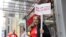 A guild member holds a placard supporting a union walk-out, outside the New York Times building in Manhattan, New York, Dec. 8, 2022.