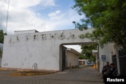 FILE - Police sit outside the facilities of La Prensa newspaper, a long-standing newspaper critical of President Daniel Ortega, after the Nicaraguan government took over the facilities to turn the space into a "cultural center," in Managua, Nicaragua Aug. 23, 2022. (REUTERS/Stringer)