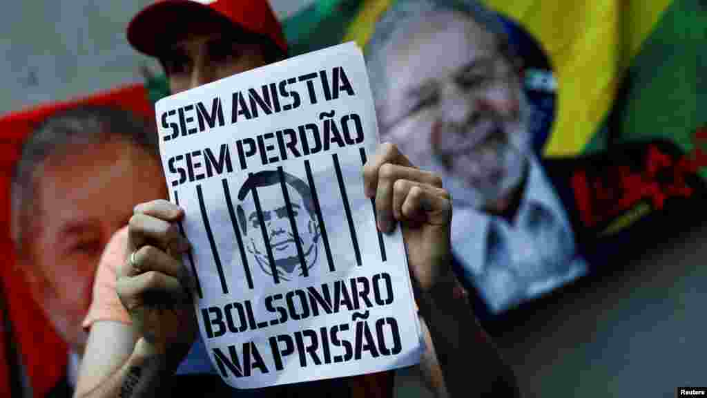 Un manifestante a favor de la democracia sostiene un cartel con una imagen que representa al expresidente de extrema derecha Jair Bolsonaro y el escrito &quot;sin amnistía, sin perdón, Bolsonaro a prisión&quot;.