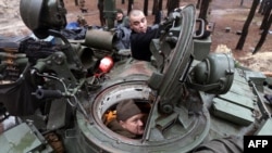 Ukrainian servicemen repair a captured Russian tank in a forest near the front line in the Kharkiv region on Nov. 26, 2022, amid the Russian invasion of Ukraine. 