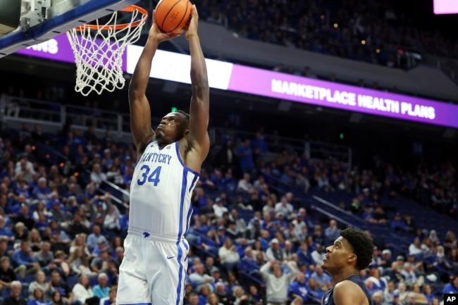 FILE - Kentucky's Oscar Tshiebwe (34) dunks during the first half of an NCAA college basketball game in Lexington, Kentucky on Nov. 23, 2022. (AP Photo/James Crisp)