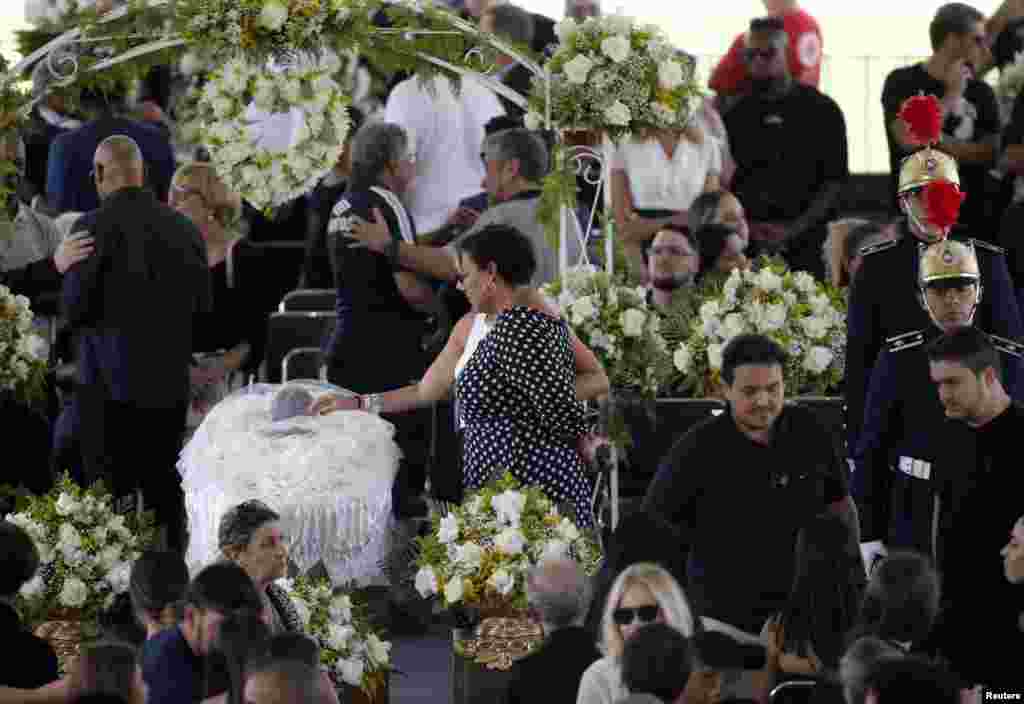 Pele&#39;s daughter, Kelly Cristina Nascimento, is seen next to the body of Brazilian soccer legend Pele in his casket, as he lays in state on the pitch of his former club Santos&#39; Vila Belmiro Stadium in Santos.