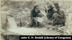 FILE - "Old timers, Spriggs, Lamb and Dillon at work" panning for gold (pay dirt) at Rockervill, S.D., in the Black Hills, 1889. (John C. H. Grabill/Library of Congress)