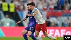 Tiền đạo số 10 Lionel Messi của Argentina (trái) tranh bóng cùng tiền đạo Robert Lewandowski số 9 của Ba Lan trong trận đấu ngày 30/11 tại sân vận động 974 ở Doha, Qatar.