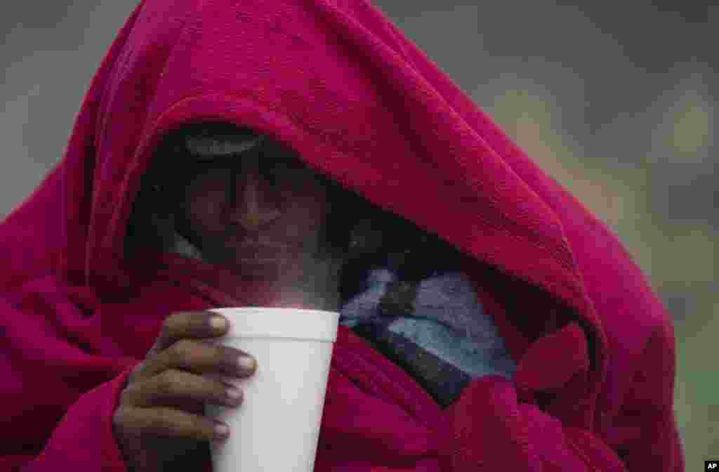 A migrant from Venezuela drinks a hot coffee amid cold weather at a makeshift camp along the Rio Grande riverbank on the U.S.-Mexico Border in Matamoros, Mexico.
