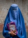 FILE - Arefeh, 40, an Afghan woman, leaves an underground school in Kabul, July 30, 2022. She attends this school with her daughter, who like other teenage girls is not allowed to go to public school.