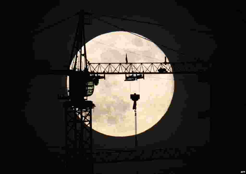 The last full moon of the year, known as the Cold Moon, rises behind a construction site in Ankara, Turkey.