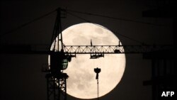 The last full moon of the year, known as the Cold Moon, rises behind a construction site in Ankara, Turkey.