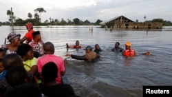 Des habitants dans l'eau à la suite d'une inondation massive dans la communauté d'Obagi, dans l'État de Rivers, au Nigéria, le 22 octobre 2022. 