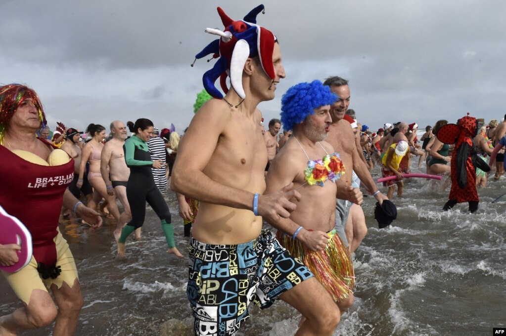 La gente participa en un baño de mar tradicional "disfrazado" para conmemorar las celebraciones de Año Nuevo en Gruissan, sur de Francia, el 1 de enero de 2023. [ AFP]