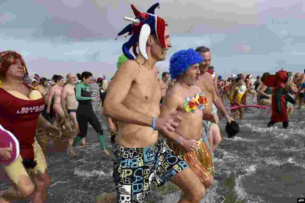 La gente participa en un baño de mar tradicional &quot;disfrazado&quot; para conmemorar las celebraciones de Año Nuevo en Gruissan, sur de Francia, el 1 de enero de 2023. [ AFP]